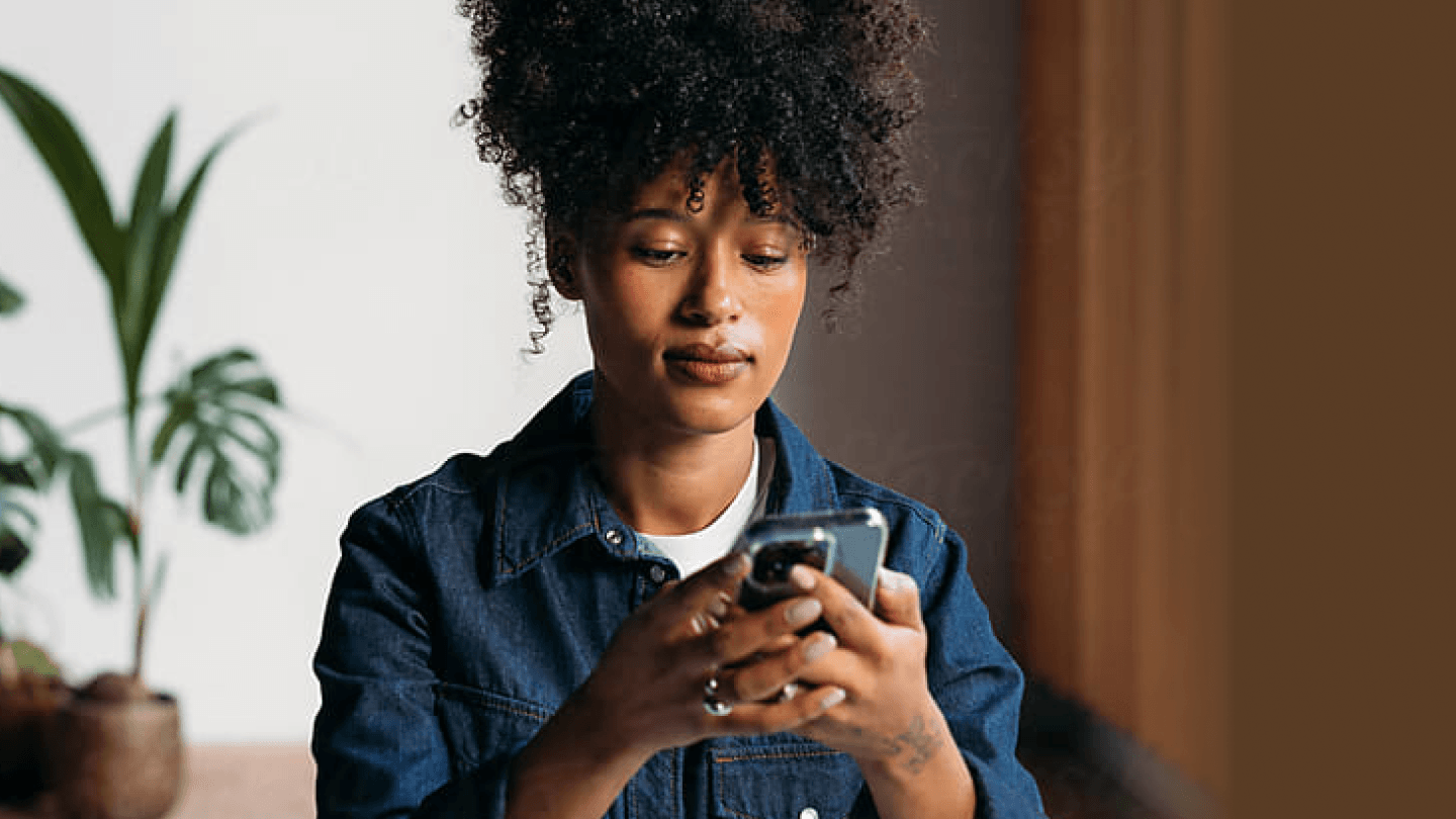 Young woman checking her phone while reviewing a bond ladder strategy