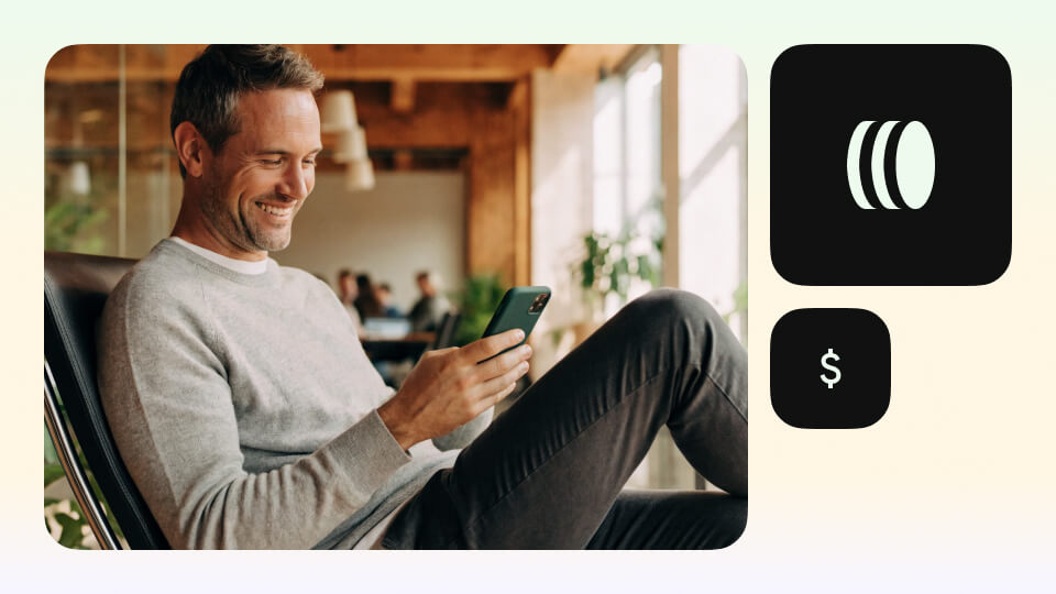 Mann informiert sich am Smartphone über ETF investieren in einem modernen Coworking-Büro