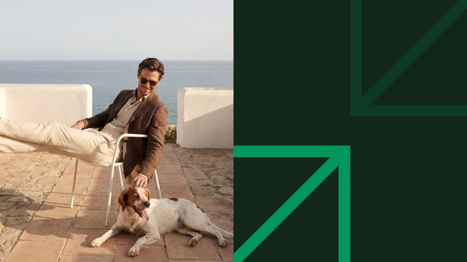 Man relaxing by the ocean with his dog, representing financial freedom and peace of mind from investment returns