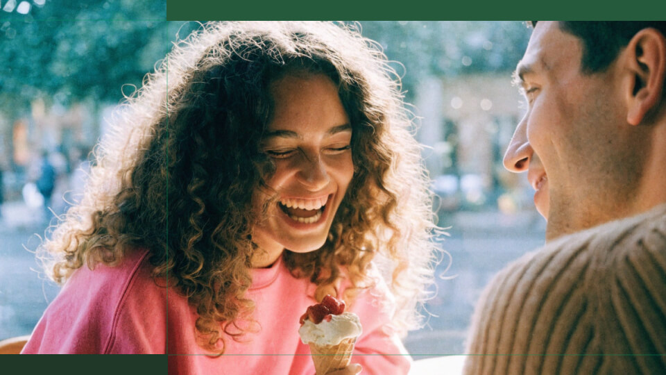 Pareja joven sonriendo mientras disfrutan de helado en la calle - concepto de inversión en acciones y crecimiento financiero personal