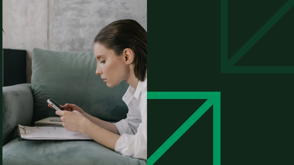 A woman scrolling on her phone looking for best investment platforms.